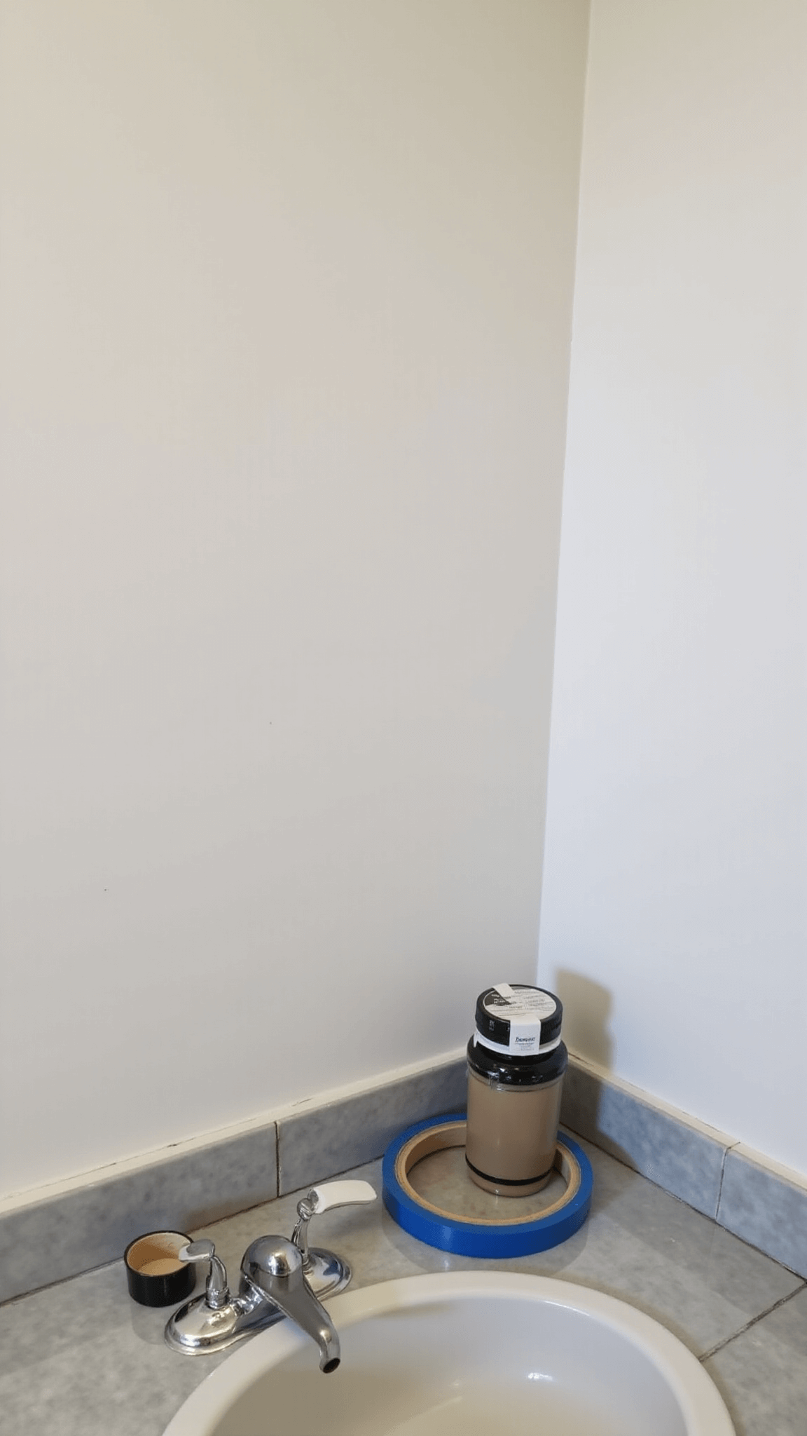 Renovated 6x6ft powder room with fresh white ceiling and color walls, featuring professional painting tools on marble countertop, sharp lines from painter's tape, and bright lighting showcasing precision and quality.